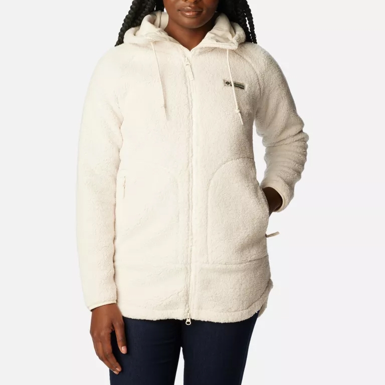 A person wearing a white fleece jacket with a hood and a zip front closure.