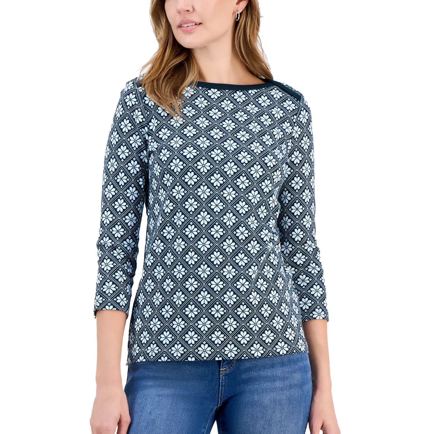 Woman wearing a diamond-patterned, long-sleeve top with a round neckline, paired with blue jeans.