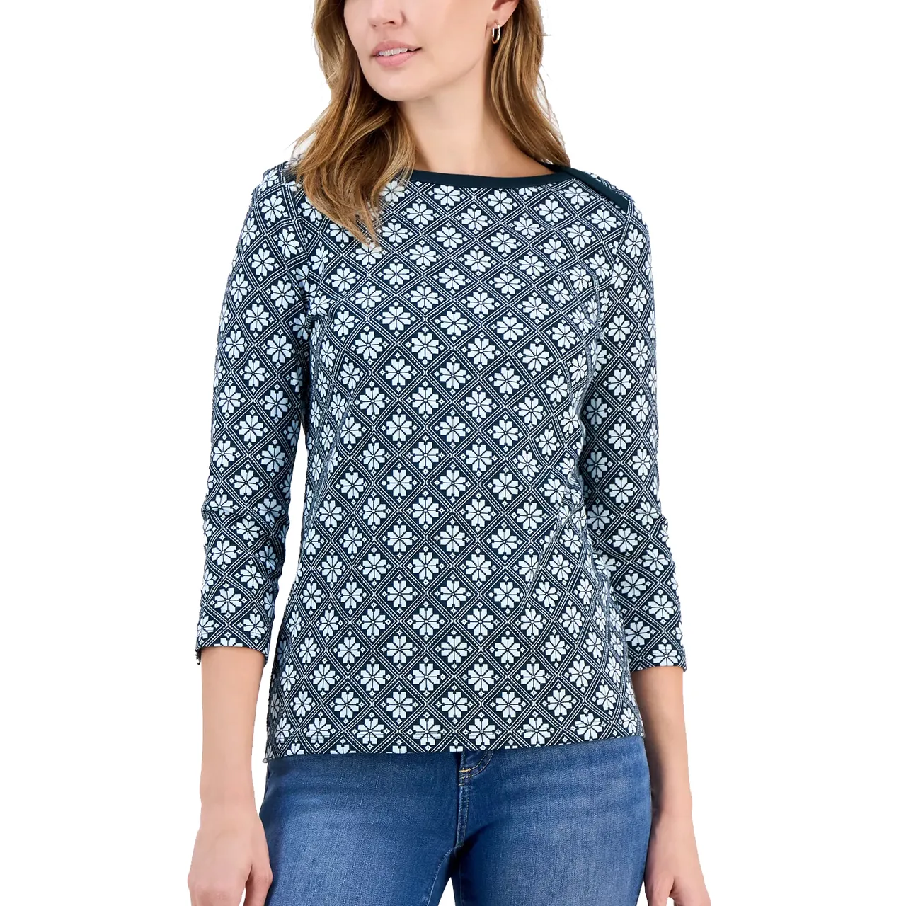 Woman wearing a diamond-patterned, long-sleeve top with a round neckline, paired with blue jeans.