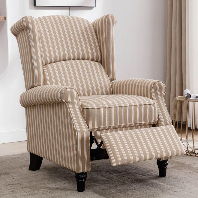 Beige-striped wingback recliner featuring rolled arms, a high back, and extended footrest, set on dark wooden legs in a modern living room.