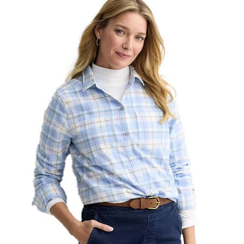 A woman is wearing a light blue plaid button-up shirt over a white turtleneck, paired with dark jeans and a brown belt.