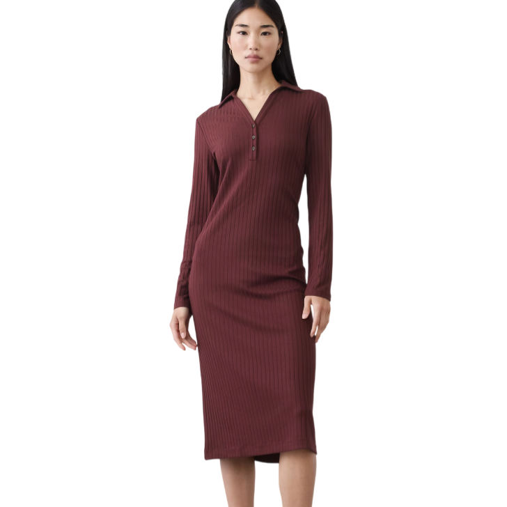 A woman is wearing a ribbed, burgundy long-sleeve midi dress with a buttoned neckline, paired with black ankle boots.