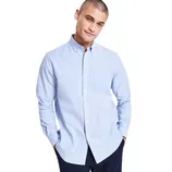 A man is wearing a light blue button-up shirt with long sleeves, paired with dark pants.