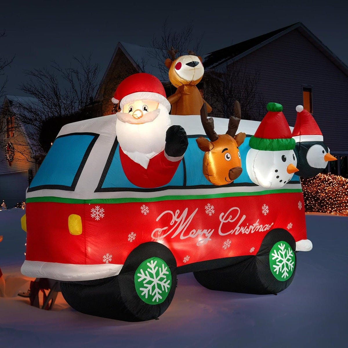 Inflatable Christmas decoration featuring Santa, a reindeer, a snowman, and a penguin in a festive vehicle with \“Merry Christmas\“ on the side and snowflakes on the wheels.