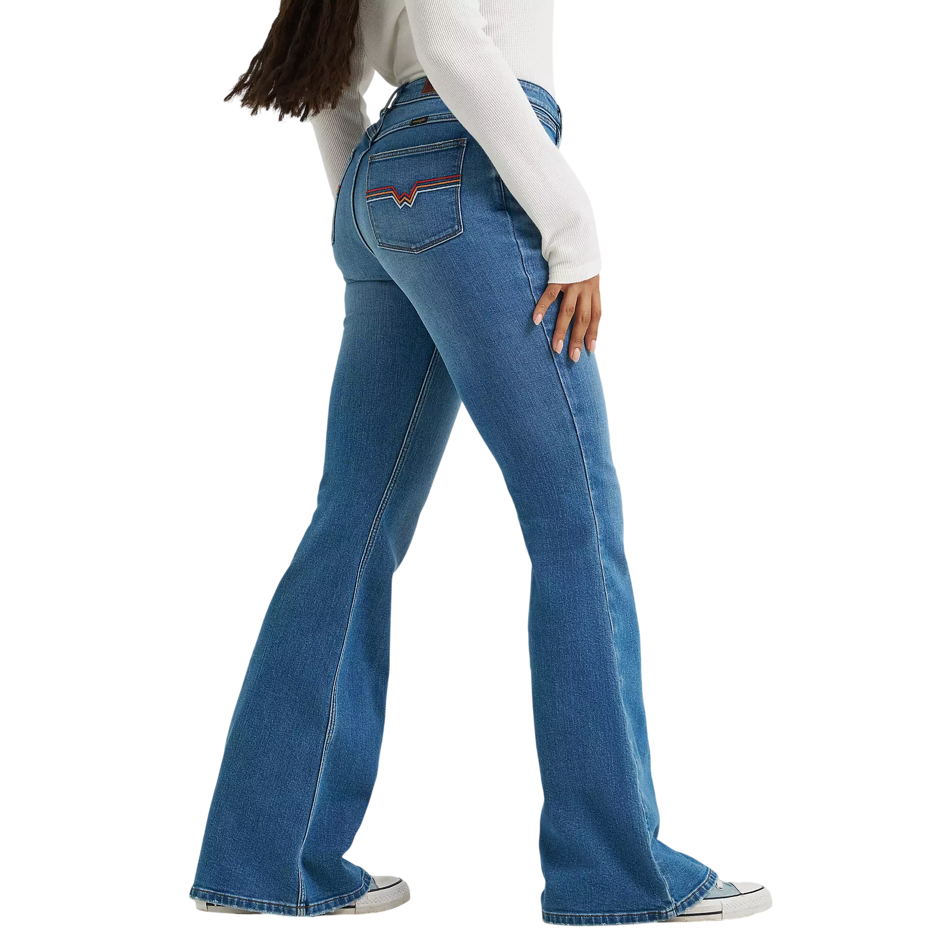 Blue flared jeans with red and blue stitching on the back pockets, paired with white sneakers and a long-sleeve white top.