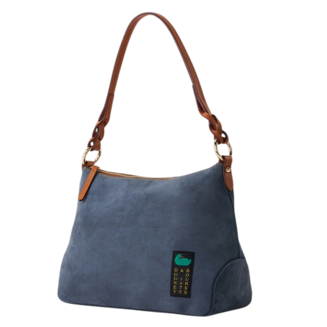 A blue suede shoulder bag with brown leather straps and a zip closure, featuring a small green and black label with text.