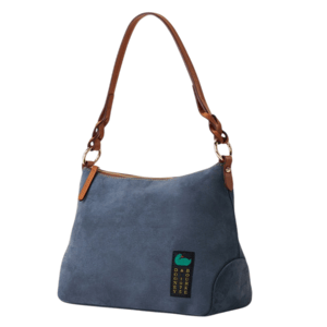 A blue suede shoulder bag with brown leather straps and a zip closure, featuring a small green and black label with text.