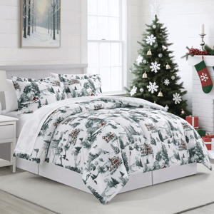 A cozy bedroom features a winter-themed comforter set with tree and house patterns. The room is decorated for Christmas with a tree, stockings, and wrapped gifts, complemented by a snowy forest painting and neutral decor.