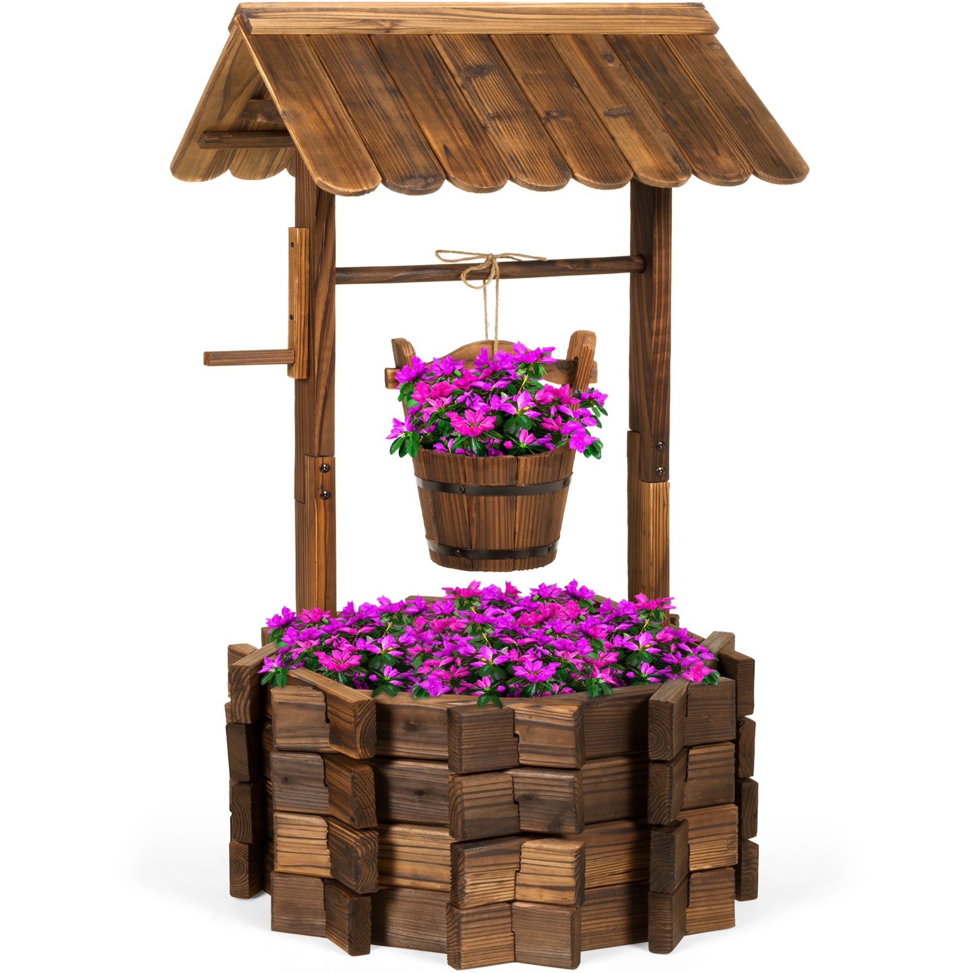 A decorative wooden wishing well planter with a roof, holding vibrant pink flowers in the hanging bucket and around the base.