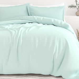 A mint green queen duvet cover set with two matching pillowcases, featuring a smooth and soft fabric texture, draped over a bed.