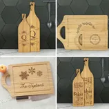 Four wooden cutting boards with personalized engravings, including names, initial designs, snowflakes, and word art.