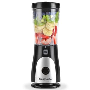 A Toastmaster Mini Personal Blender with a clear blending cup filled with fruit, featuring measurement markings, a black and silver base, and a single control button.