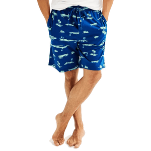 Blue shorts with a tropical palm tree print, featuring an elastic waistband and drawstrings, worn by a person standing barefoot.