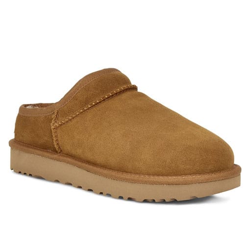 Suede slippers with a slip-on design, featuring a smooth upper, a round toe, and a chunky, ribbed sole. The color is a uniform tan.