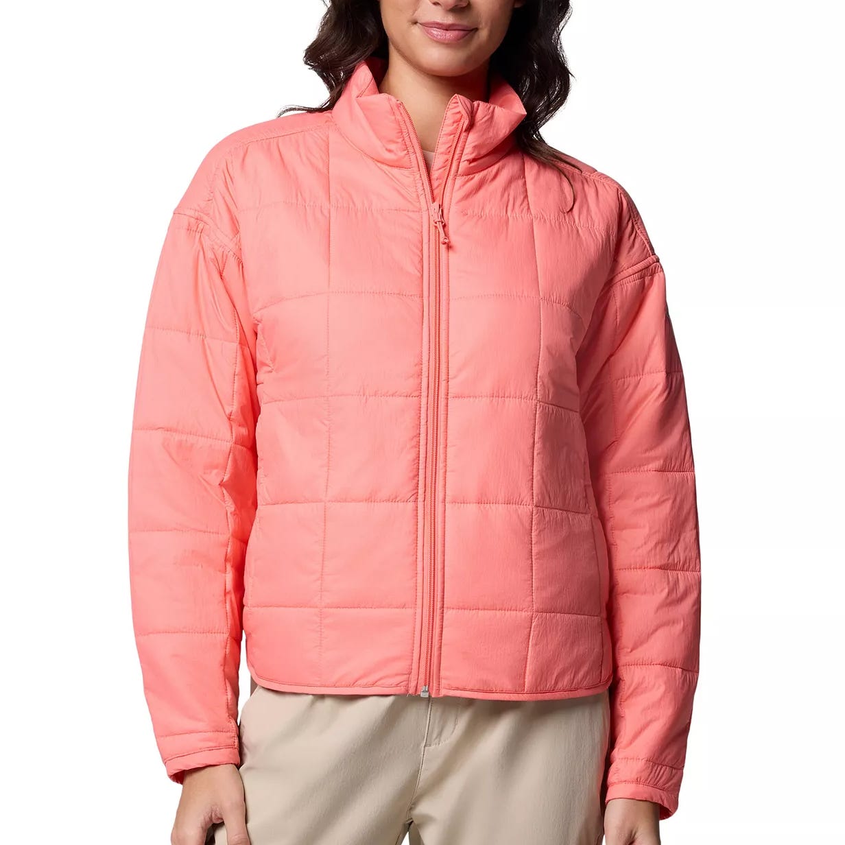 Coral pink quilted jacket with a front zipper, high collar, and long sleeves, paired with beige pants.