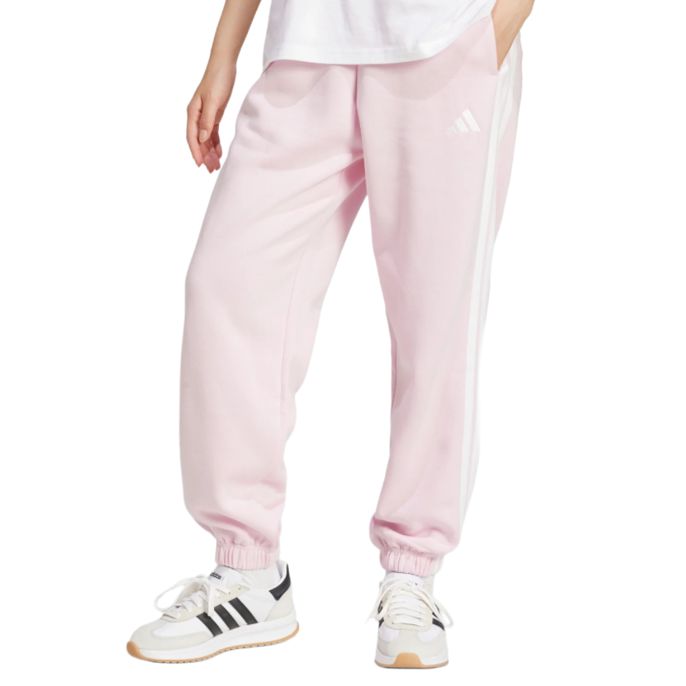 Pink Adidas sweatpants with white side stripes, paired with white Adidas sneakers featuring black stripes and tan soles.