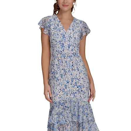 A woman wearing a knee-length, short-sleeve, floral-print dress with a V-neck and tiered ruffles in blue and white tones.