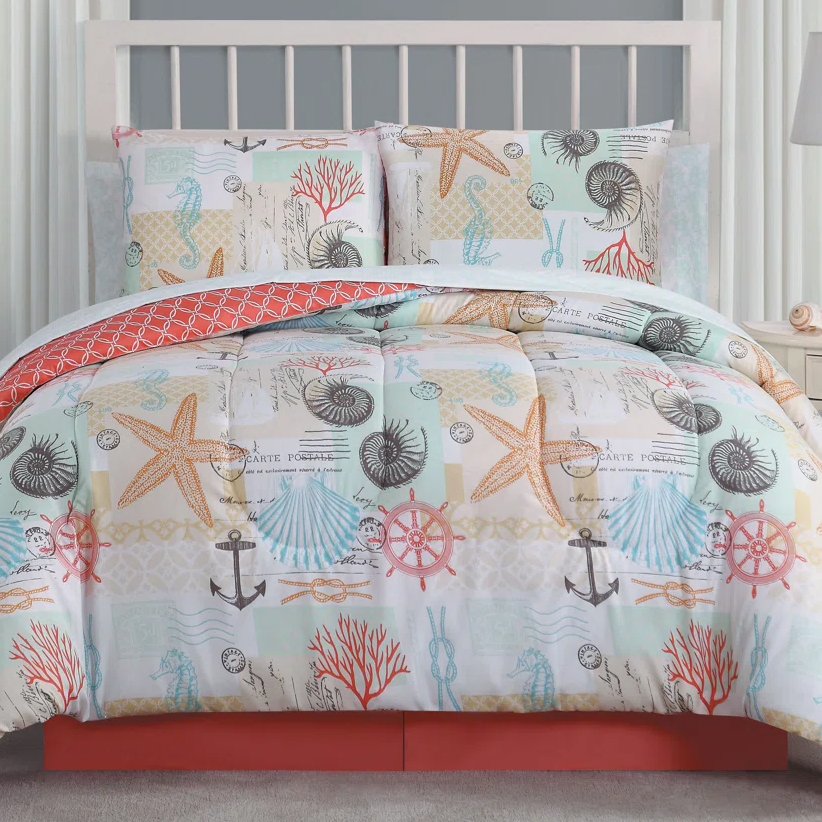 8pc Queen Coastal Comforter Set featuring a nautical theme with starfish, seashells, and anchors in blue, orange, and coral tones. Includes a reversible comforter, matching pillow shams, and coordinating bed skirt with a coral print.