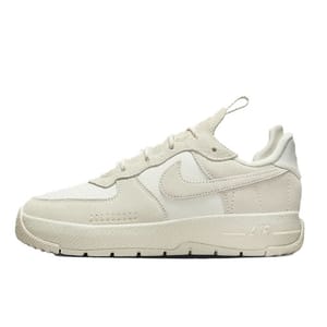 A beige Nike sneaker featuring a suede and mesh upper with a textured rubber sole, showcasing the iconic Swoosh logo on the side.