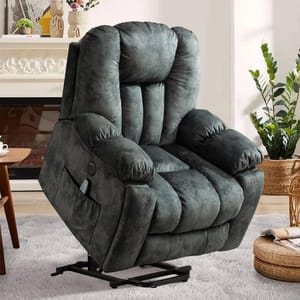 A plush, dark gray reclining lift chair with a side pocket contains a remote control, placed in a cozy living room setting with plants and a fireplace.