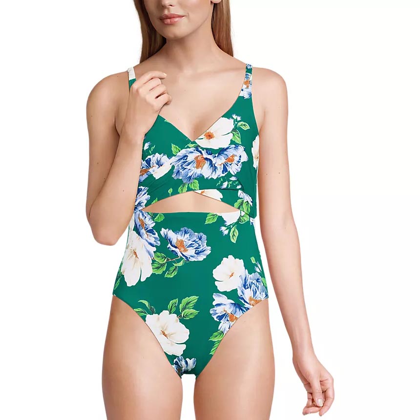 Floral print one-piece swimsuit with a crisscross neckline and cutout detail on a green background.