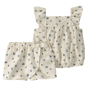 A cream-colored toddler outfit with blue floral prints, featuring a sleeveless top with ruffle straps and matching shorts with a bow detail at the waist.