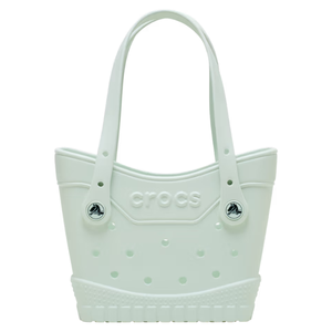 A white Crocs tote bag with signature ventilation holes, featuring the Crocs logo and adjustable strap adorned with black-and-white Crocs buttons.