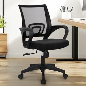 Black mesh office chair with curved armrests, adjustable height, and a five-wheel base, placed in a modern office setting with a desk and minimal decor.