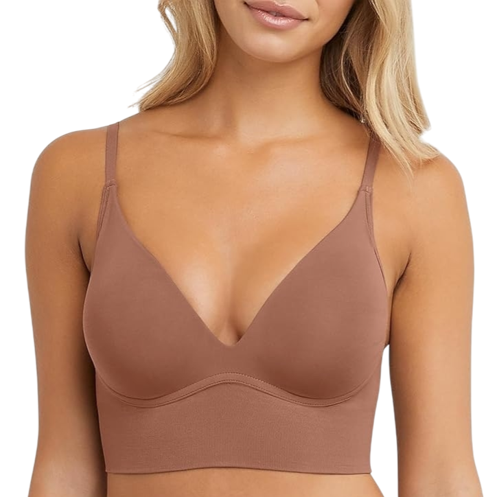 A woman is wearing a brown seamless longline bra with thin adjustable straps and a deep V-neck design.