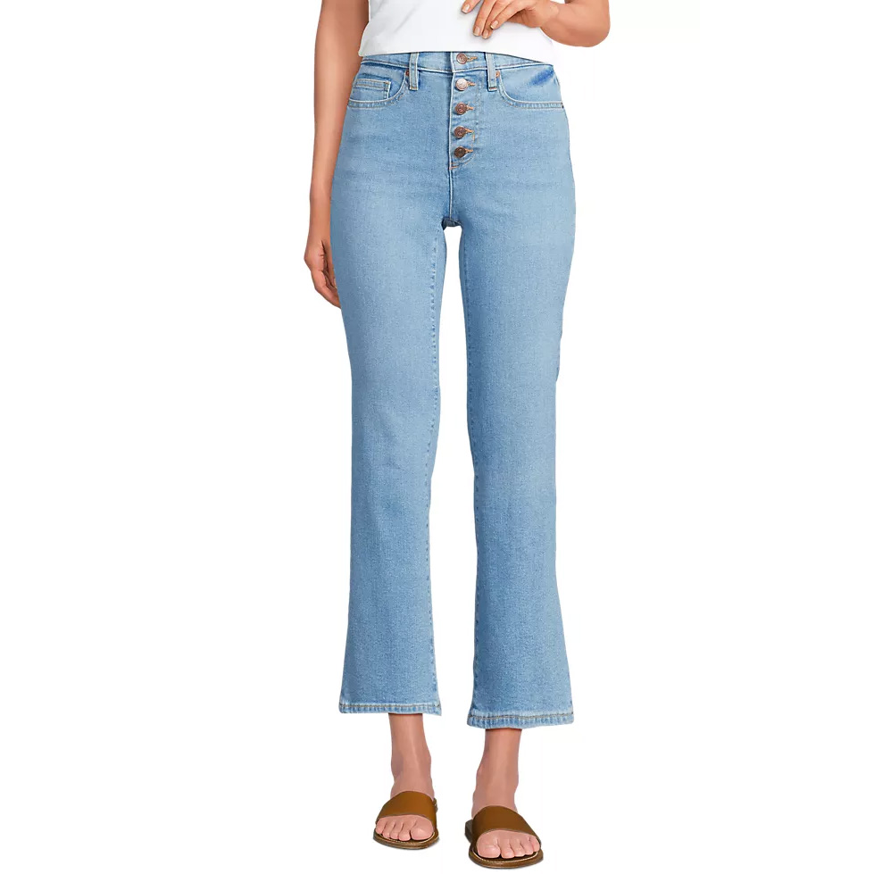 Light blue high-waisted jeans with a button fly and slight flare, paired with brown slide sandals.