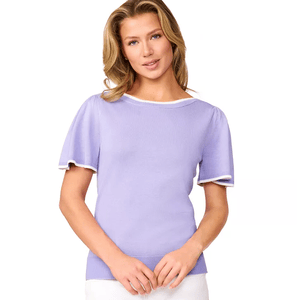 A woman is wearing a light purple short-sleeve top with white trim on the collar and sleeves, paired with what appears to be white bottoms.