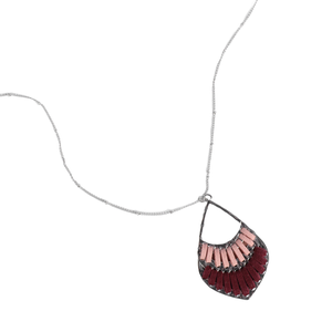 Silver necklace with a pendant featuring a geometric design, showcasing an arrangement of red and pink segments.