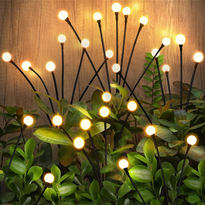 Decorative floor lamp with multiple stems and round bulbs paired with green leafy plants against a wood backdrop.