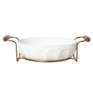 A white 3-quart stoneware baking dish with embossed design, placed on a gold-tone metal rack with wood handles.