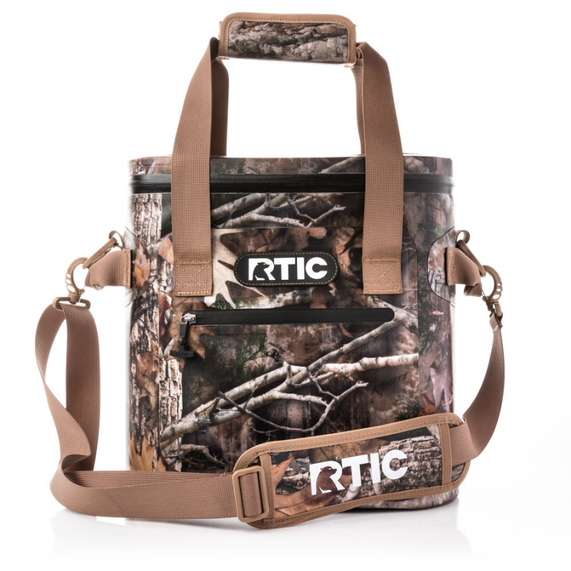 RTIC 20 Can Cooler Bag features a camouflage design with tan straps and a logo on the front. It includes a zippered front pocket, shoulder strap, and padded handles.