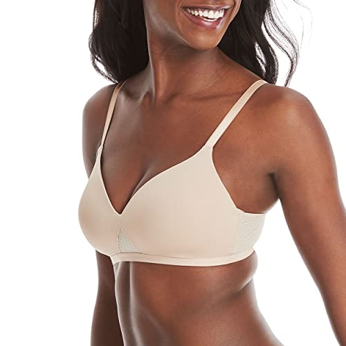 A light beige t-shirt bra with smooth, seamless cups and mesh detail along the sides, featuring adjustable shoulder straps.