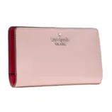 A pink Kate Spade New York wallet with a smooth texture and red interior.