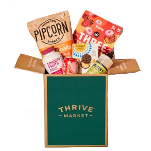 A Thrive Market box containing Pipcorn snacks, SmartyPants vitamins, Three Wishes cereal, Simple Mills crackers, Bare Bell protein bar, Herr's cheese balls, and Mrs. Meyer's hand soap.