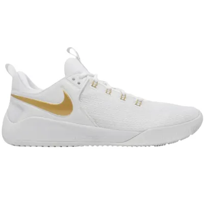 A white athletic shoe with a gold Nike swoosh logo, featuring a textured upper and cushioned sole.