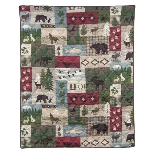 Patchwork quilt featuring woodland animals and nature motifs, including bears, deer, pine trees, and plaid patterns in earthy colors.
