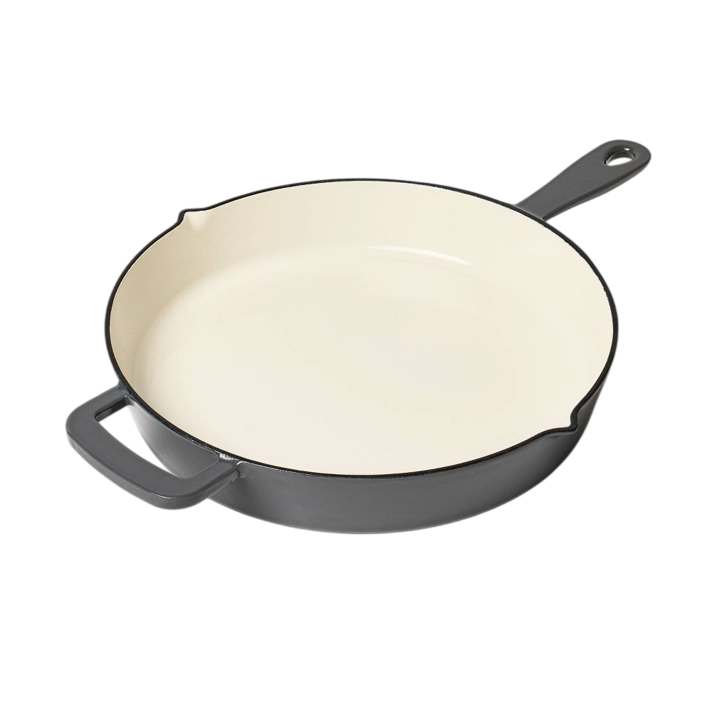 Black and cream enameled cast iron skillet with dual handles and pour spouts.
