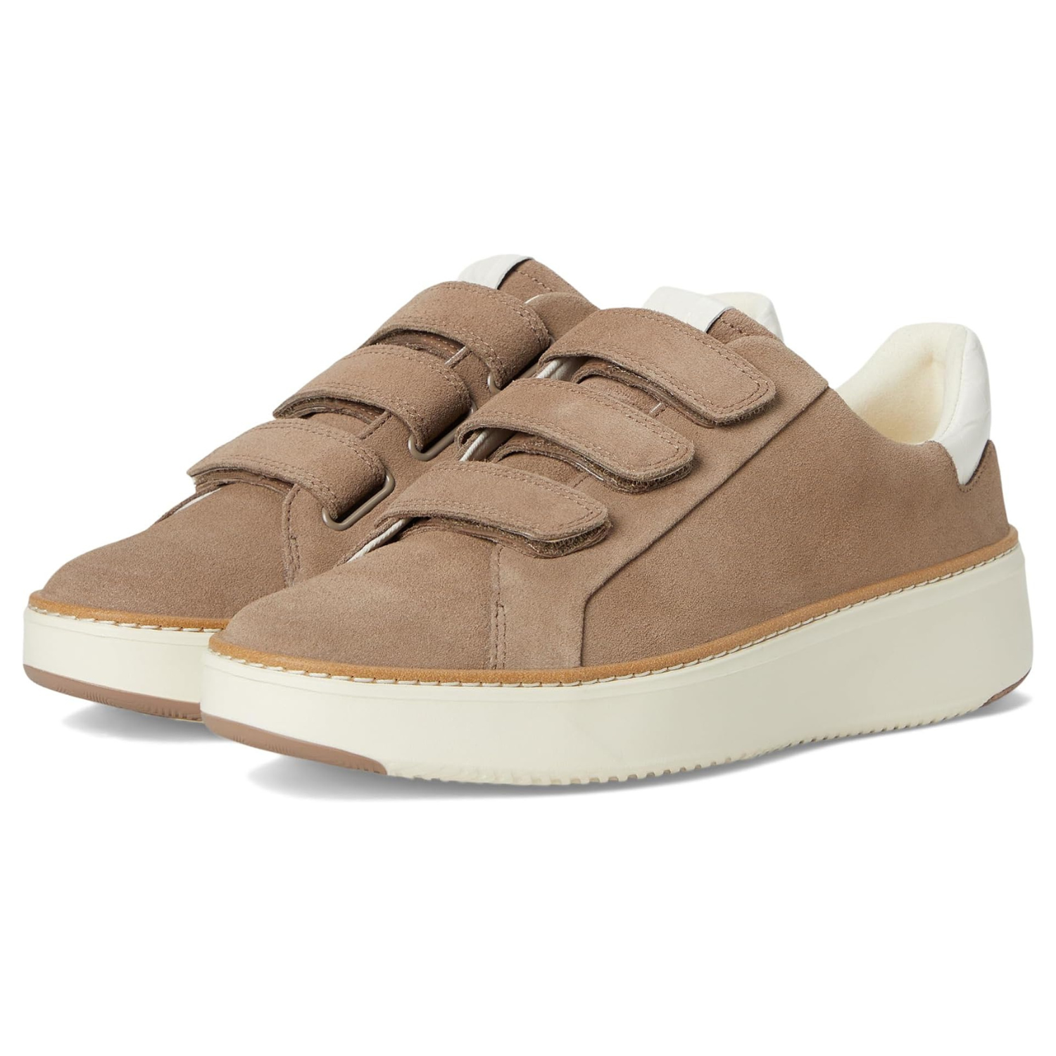 Cole Haan Triple Strap Sneakers feature a taupe suede upper with three velcro straps, a white cushioned collar, and a thick white rubber sole for comfort and style.