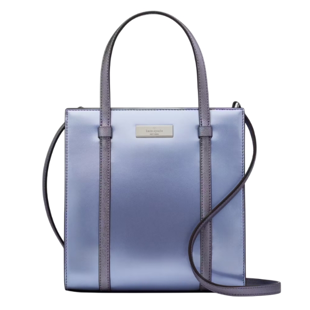 A metallic blue and purple tote bag with a structured, rectangular shape, featuring dual top handles and a crossbody strap. The front has a small metal logo plaque.