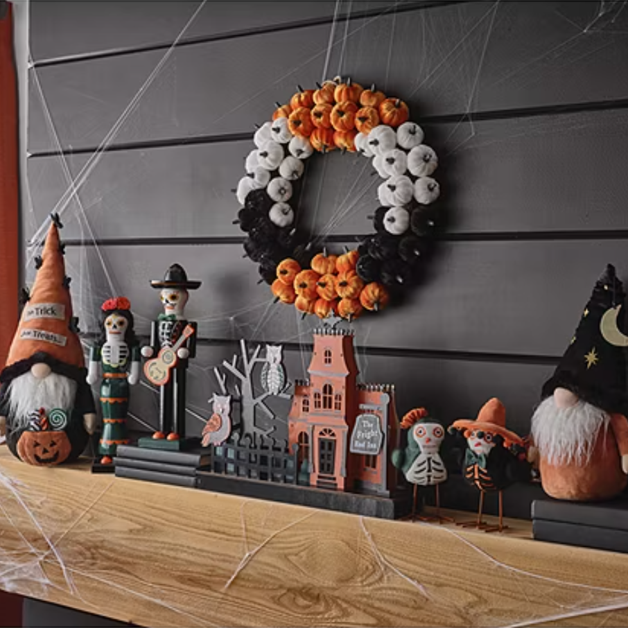 A collection of Halloween-themed decorations including figurines, a wreath, and a haunted house display.