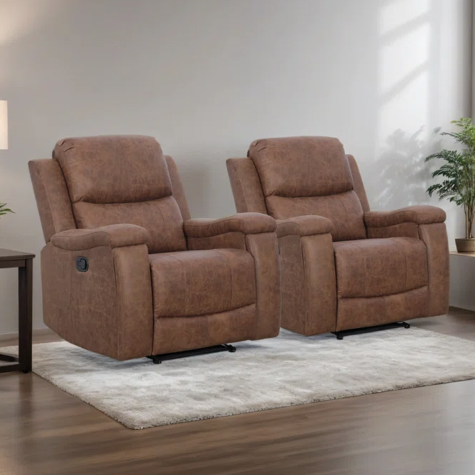 Two brown recliner chairs are placed side by side on a light-colored rug, between a lamp on a small table and a potted plant, set in a well-lit living room.