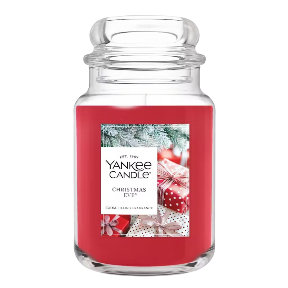 Yankee Candle \“Christmas Eve\“ large jar with a red wax and festive label featuring gifts and snow-covered branches.