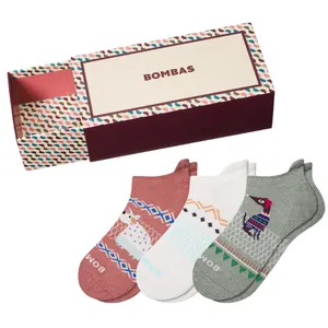 A box set of Bombas socks featuring three pairs in different colors with playful animal designs. The box has a colorful geometric pattern.