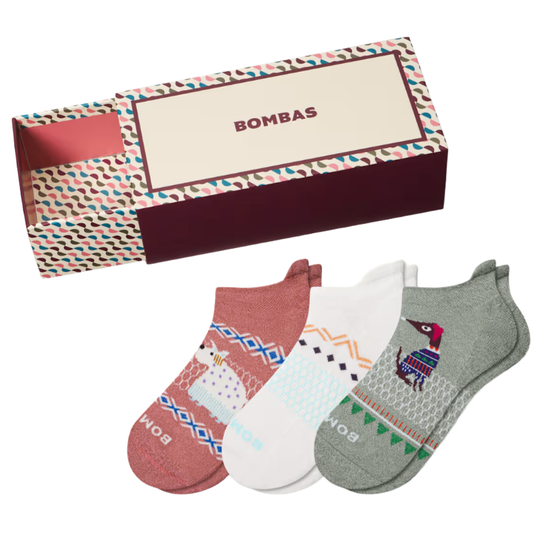 A box set of Bombas socks featuring three pairs in different colors with playful animal designs. The box has a colorful geometric pattern.