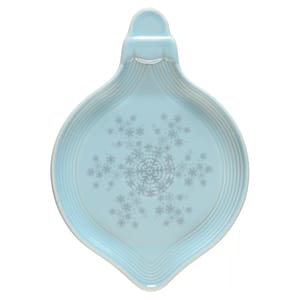 Light blue spoon rest with a snowflake pattern, featuring a round, shallow design and a handle.
