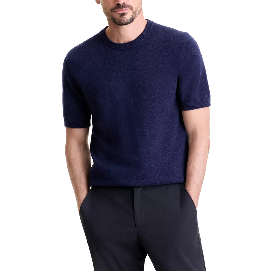 A man is wearing a short-sleeved navy knit sweater paired with dark pants.